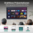Personen sehen sich Inhalte auf einem großen interaktiven Display an, das kabellose Präsentationen über Miracast oder AirPlay zeigt. Auf dem Bildschirm sind Streaming-Apps wie Netflix, YouTube und Prime Video zu sehen. Unten werden Geräte wie Desktop, Laptop, Tablet und Smartphone als kompatible Quellen dargestellt.